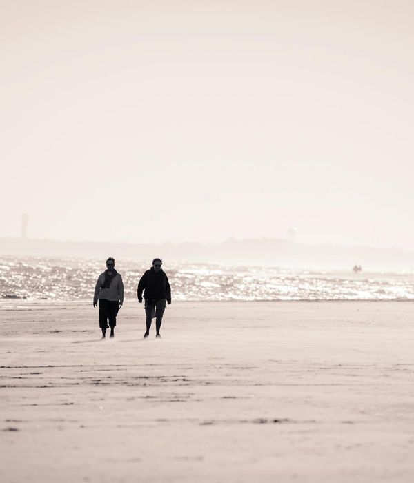 Person stretching gently outdoors during a sunrise with soft light.